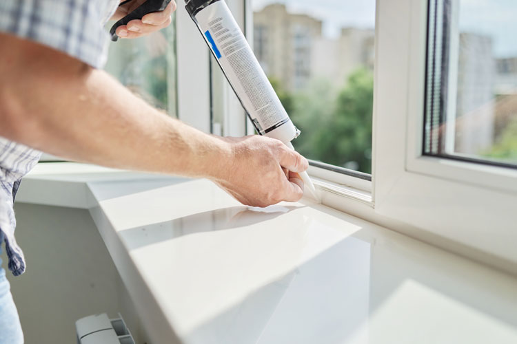 Worker filling seams with caulking